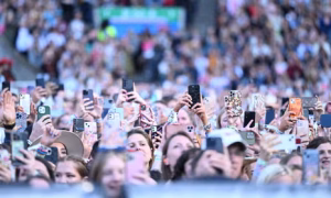 pubblico ad un concerto che riprende l’evento con smartphone